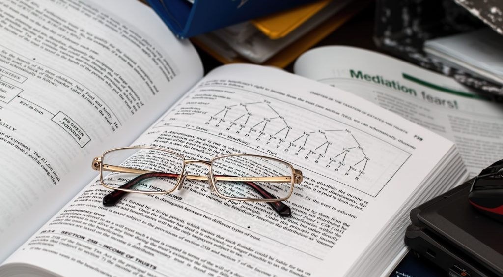 A pair of reading glasses on top of a textbook