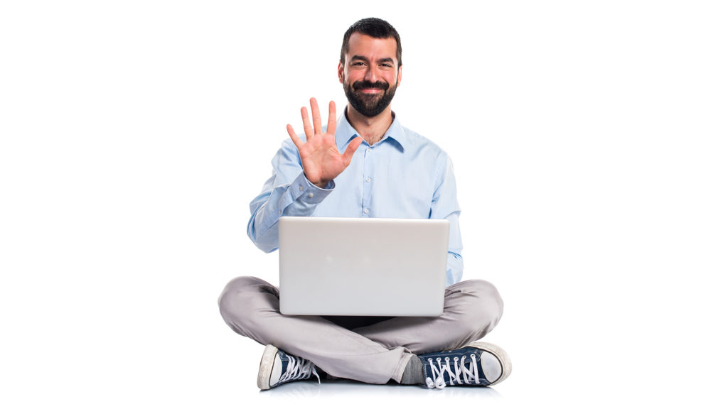 Man sitting down in front of his laptop holding up five fingers.